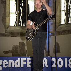 ein Mann, der eine Gitarre hält