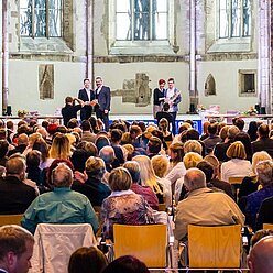 ein Mann, der vor einer Menge in einer Kirche steht