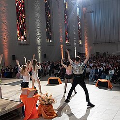 eine Gruppe von Menschen, die in einer Kirche tanzen