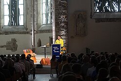 ein Mann, der auf einem Podium in einer Kirche steht